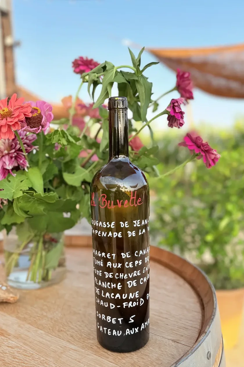 Le vigneron du Domaine Allegria présentant sa collection de vins dans l'œnothèque lors d'une visite guidée à Pézenas